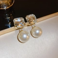 Macro view of gold stud earrings with square cubic zirconia and large white pearls - 48# Gold Square Pearl