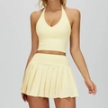 Two-piece pale yellow yoga set featuring halter crop top and pleated tennis skirt - S / Top And Bottom / Creamy Yellow