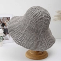 Handcrafted grey wide-brim crochet sun hat displayed on a wooden stand in a lifestyle scene - Gray