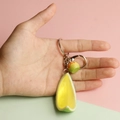 Detailed view of PVC lemon slice keychain held by hand to show actual scale and texture - Grapefruit Wedge