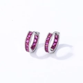 Macro detail of silver hoop earrings with square-cut red zircon stones on white background - Silver Red Zirconia