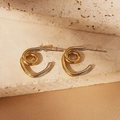 Close-up of two-tone spiral knot earrings in gold and silver finish on stone base - Mixed Metal Spiral Knot Style