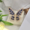 Luxury gold butterfly open ring with blue zircons on a fresh floral background - Gold Blue Zircon