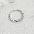 Silver geometric bow open ring with zircon stones on white textured stone background - Leaf Zirconia Style - Silver
