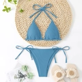 Flat lay of gray blue ribbed triangle bikini set with straw mat and summer accessories - Blue