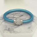 Detail von seeblauem Silikonarmband mit zylindrischem Magnetverschluss und Pavé-Kristallen - Blaugrün