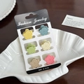 Set of 6 mini flower hair clips in macaron colors displayed on a shell plate - Set 13
