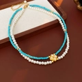 Collier double rang avec perles turquoise, perles blanches et pendentif trèfle doré - Bleu/Blanc