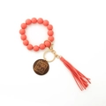 Détail du porte-clés bracelet en perles silicone rose corail avec pendentif MAMA et pompon - Rouge Pastèque