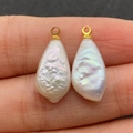 Zwei natürliche weiße Tropfenperlenanhänger mit goldenen Ringen auf Fingern zur Größe - Nr. 3 (10x22mm)