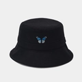 Dettaglio del ricamo a farfalla blu sul tessuto di cotone nero di un cappello da pescatore - Nero