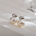 Detailed close-up of vintage silver oval metal studs with warm white pearls on leather - Pearl Silver