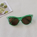 Detail of green cat-eye sunglasses with metal rivets on textured white background - Parrot Green