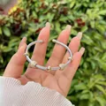 Dettaglio del bracciale rigido a treccia in argento con sfere in oro e zirconi al polso - Anello d'oro pavé sfera di zirconia (2)