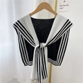 Châle en tricot à rayures noires et blanches sur cintre en bois devant rideau blanc - Motif à Rayures Encadrées
