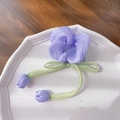 Purple tulip scrunchie with green ribbons and flower charms on white plate - Pearl Purple Hair Tie