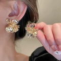 Golden petal flower stud earrings with metallic pleated design on female model - Gold Pleated Three-Dimensional Large Flower