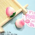Dettaglio di un ciondolo a pesca in resina da 1,8 cm con sfumatura rosa per creazioni DIY - Pesca