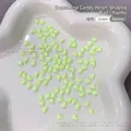 Macro shot of 4x5mm green heart resin nail art charms displayed in a white ceramic dish - 100 Pieces Set / Green