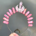 Macro shot of handmade aura quartz crystal crown featuring a silver moon ornament - Pink