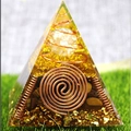 Orgone pyramid with gold foil and copper spiral coils on a green grass background - XQK05 Double Helix
