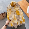 Détail d'une écharpe en coton et lin à fleurs jaune et beige avec un sac en paille - Jaune