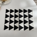 Detailed close-up of geometric triangle placemat with high-quality stitched edges - Black Triangle