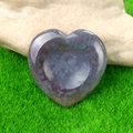 Polished heart-shaped gray and purple worry stone on green grass background - India Agate