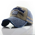 Detailed close-up of distressed denim baseball cap with vintage embroidery and worn edges - Khaki + Blue