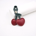 Detail of red cherry leather bag charm with green leaves and gold metal snap button - Burgundy