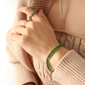 Vintage gold-plated bracelet set with emerald green zircon crystals worn on wrist - Green Zircon Bracelet
