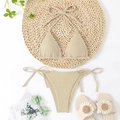 Flat lay of beige ribbed triangle bikini with neck straps and side-tie bottom on straw mat - Off White