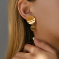 Close-up of gold double-layered heart earrings with brushed metal texture on female ear - Brushed Double Round - Gold (KE0431)