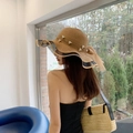 Detail of straw sun hat featuring white pearl trim and a brown mesh mesh ribbon bow - Lotus Pearl Khaki