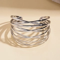 Detailopname van de zilveren gelaagde cross-manchetarmband met hooggepolijste metallic glans - Zilver
