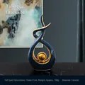 Modern tall blue and gold ceramic sculpture with a sleek hollow design and gold sphere - Blue Gold (Tall)