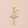 Golden cross keychain with white rhinestones and star pattern on pink background - Kc Gold 10530