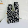 Detailed knit tote bag featuring black and white paisley patterns with wide strap design - Paisley Black