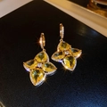 Gold earrings featuring yellow pear-cut zircon petals on a black textured background - Golden Four-Leaf Clover Yellow Zircon Hoop (52#)