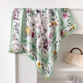 Dettaglio di foulard in seta con motivi floreali variopinti e bordi verdi rifiniti - Verde