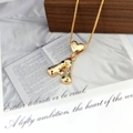 Macro shot of gold letter A pendant with colorful stones and heart bail on wood - Letter A