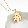 Collar con colgante de árbol de Navidad dorado calado con estrellas sobre plato cerámico - Dorado
