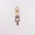 Close-up of a mini gray striped cartoon cat keychain with a gold lobster clasp - Grey and Black Striped Cat