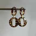 Détail de boucles d'oreilles géométriques en résine écaille sur un support en bois - 23# Résine Léopard Ovale Rond (Tige en Argent)