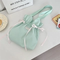 Detail einer mintgrünen Canvas-Tasche mit rosa Schleife und Kordelzug-Verschluss - Frisches Grün