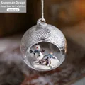 Christmas glass ball ornament with snowman and blue figure in snowy miniature scene - Snowman