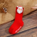 Detail of red Christmas baby sock with Santa Claus 3D decor and anti-slip sole on wood - XS / Red Small Santa