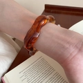Close-up of amber resin wavy bangle on wrist with a minimalist and warm aesthetic - 81# Wave Cuff-Amber