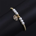 Macro detail of gold-plated evil eye charm and pearl beads on bohemian bracelet - CN001411CX Pearl/Pearl Gold Bead Colorful Zircon Eye