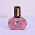 Detail of pink rhinestone essential oil diffuser with a dōTERRA lemon oil bottle on top - Luxury Rhinestone Studded - White
